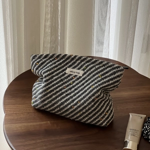 Detail of woven fabric texture on a speckled zipper pouch with simple wish label