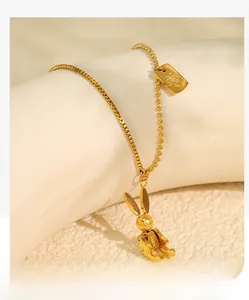 Detailed close-up of golden mechanical rabbit pendant on mixed chain with luck engraving