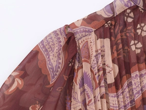 Close-up of pleated chiffon fabric with paisley floral print on a bohemian style dress