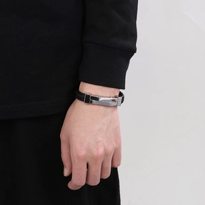 Detail of men's braided black leather bracelet with brushed stainless steel clasp