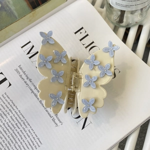 Elegant cream butterfly hair claw with blue floral patterns and sparkling crystal rhinestones
