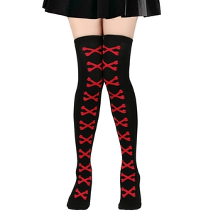 Detail of gothic over-knee socks featuring red crossbones pattern on black knit fabric
