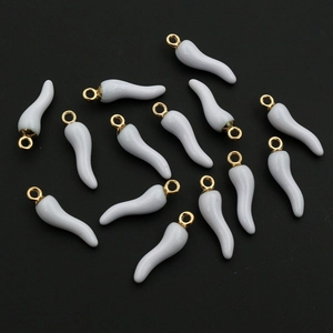 Macro shot of white enamel chili pendants on black background for jewelry DIY