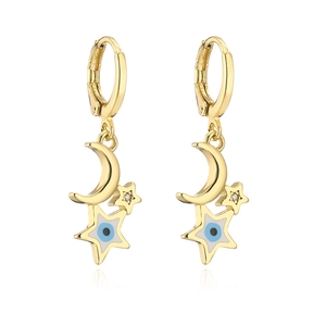 Orecchini placcati oro con pendenti a luna e stella e dettaglio occhio blu su bianco