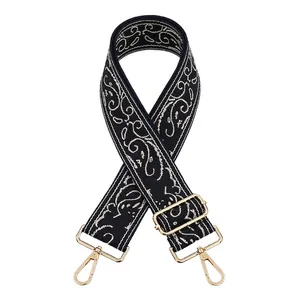 Detail of navy blue jacquard embroidered bag strap with golden metal hardware clips