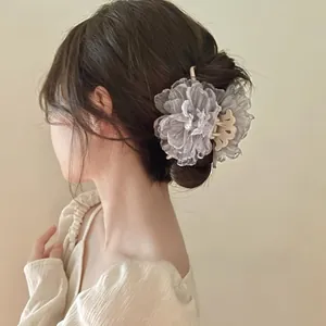 Detail von grauer Mesh-Blumen-Haarklammer mit Perle, getragen von einem Modell im Licht