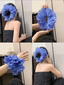 Detail of blue oversized pleated scrunchie with layered organza fabric on wrist and hair