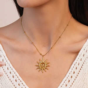 Gold stainless steel sun pendant necklace with spiral texture on model neck