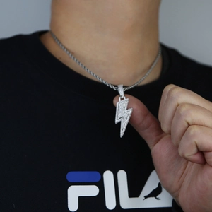 Détail du pendentif éclair hip-hop serti de zircons blancs sur une chaîne torsadée