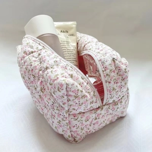 Close-up of pink floral quilted fabric makeup bag with zipper and spacious interior