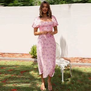 Detail of pink floral dress with puffy sleeves and square neckline in outdoor setting