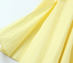 Gros plan détaillé de la robe bustier jaune montrant la texture et les froufrous plissés