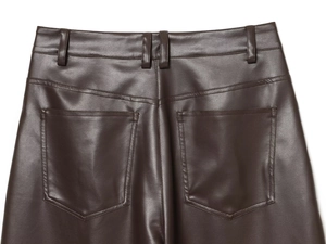 Dettaglio dei pantaloni in ecopelle marrone scuro con passanti e cuciture della tasca