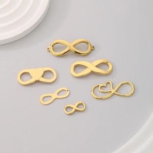 Golden infinity and heart stainless steel jewelry connectors on a grey background