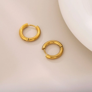 Polished minimalist 18K gold plated stainless steel hoop earrings on neutral background