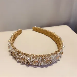 Détail macro du serre-tête tissé or champagne avec perles et cristaux brodés à la main