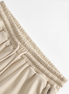 Detail of men's linen pants featuring elastic drawstring waist and woven texture