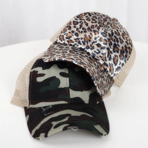 Detail of leopard print and camouflage ponytail baseball caps with mesh back and distressed brim