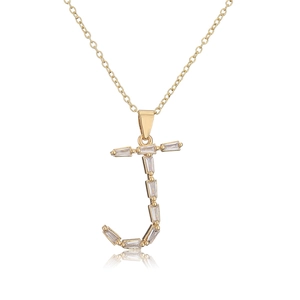 Macro shot of gold 18K plated letter J pendant necklace with baguette zircon stones