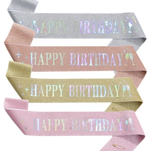 Macro detail of glitter birthday sashes in four colors with holographic lettering