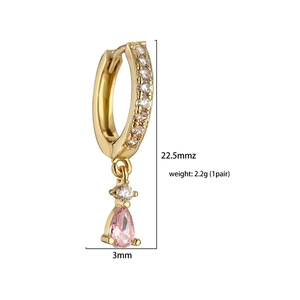 Détail de boucles d'oreilles dorées avec pierre rose en goutte et pavé de zircons