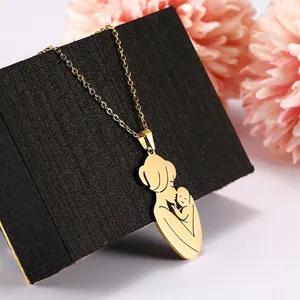 Golden stainless steel mother and child pendant necklace on a black textured jewelry box
