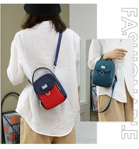 Detail of multi-pocket nylon crossbody bag with dual zip and letter print strap
