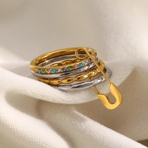 Detail of four-layer stainless steel gold rings with colorful zircons and pin charm