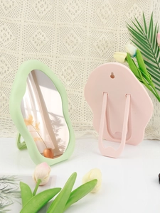 Macro view of cloud-shaped makeup mirrors showing front frames and rear foldable stands