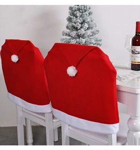 Close-up of red velvet Christmas chair covers with white plush trim and festive pom-poms