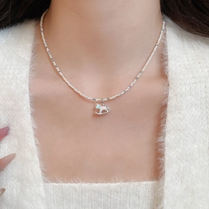Gros plan d'un collier de perles colorées avec un pendentif cheval à bascule mignon