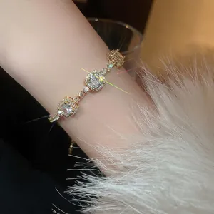 Bracelet plaqué or avec zircons carrés et détails pavés scintillants sur le poignet d'un modèle