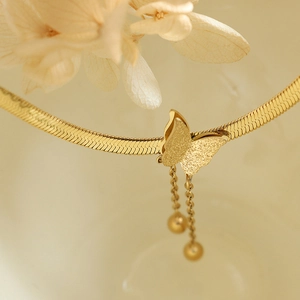 Elegant gold blade chain necklace featuring frosted butterfly pendant and playful tassels