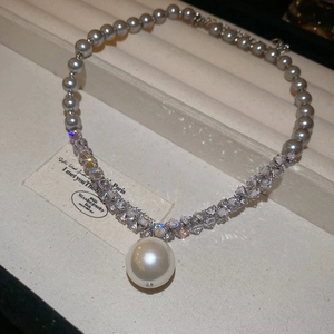 Detail of grey pearl and crystal beaded necklace with large white pearl pendant