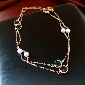 Close-up of vintage double-layer necklace with multi-color gems and white pearls