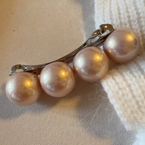 Detail showing four large pink pearls on a silver metal spring hair clip for women