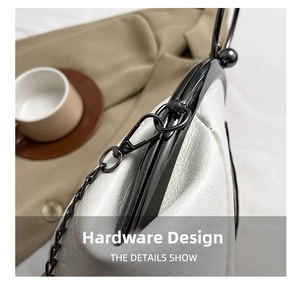 Detail showing the black lacquered metal frame and chain link on a white leather bag