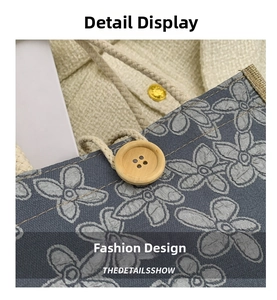 Detail of gray woven tote bag with white flower pattern, wooden button, and rope handle
