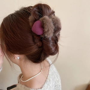 Pince à cheveux en peluche marron avec cœur violet sur un chignon élégant détail