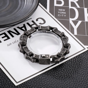 Close-up of vintage titanium steel bracelet featuring ornate engraved wave patterns