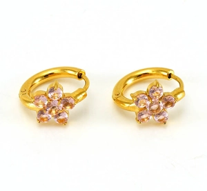 Detail shot of gold huggie earrings featuring pink zircon flower accents on white backdrop