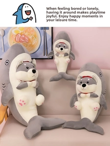 Three sizes of plush shark husky crossover toys arranged on a cozy beige sofa