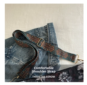 Detail of adjustable wide canvas shoulder strap with exotic mandala pattern and gold buckle