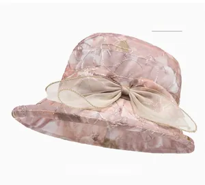 Detail of light pink sun hat featuring floral embroidery and large organza bow decoration