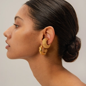 Close-up of 18k gold plated hammered flower C-shape earring and ear cuff on model