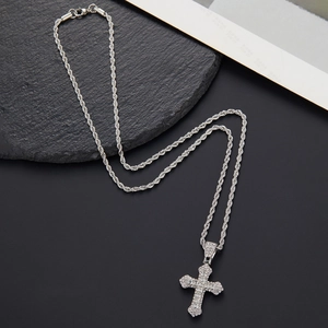 Macro shot of silver hip hop cross pendant with paved zircons and thick rope chain necklace