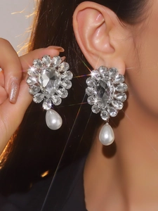 Detailed view of luxury rhinestone flower cluster earrings with drop pearls on model