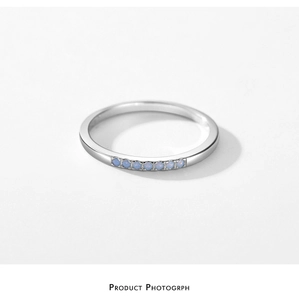 Macro detail of S925 sterling silver ring featuring micro-set opal stones on white base