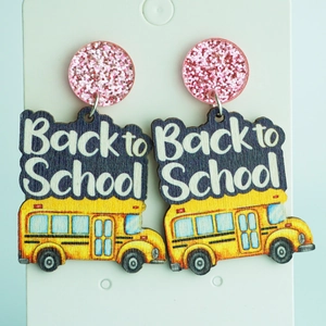 Detail of glitter pink studs and yellow school bus earrings with Back to School text