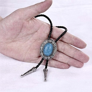 Macro view of vintage silver bolo tie featuring oval turquoise gem and woven leather cord
